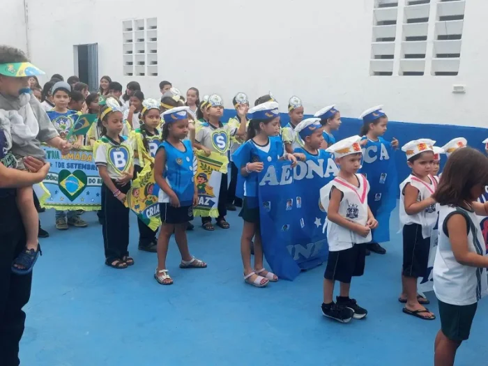 Alunos do colégio uniformizados participando de desfile cívico comemorativo