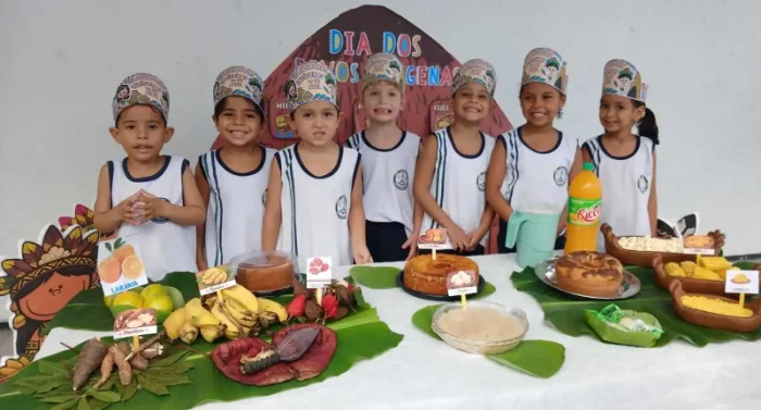 Crianças da Educação Infantil reunidas com cocares temáticos em celebração ao Dia dos Povos Indígenas